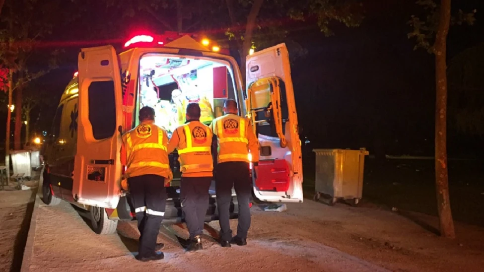 Una ambulancia con efectivos atendiendo al joven herido en una reyerta en Madrid