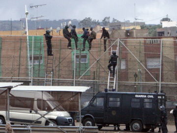 Imagen de archivo de migrantes subidos a la valla de Melilla Imagen de archivo de migrantes subidos a la valla de Melilla