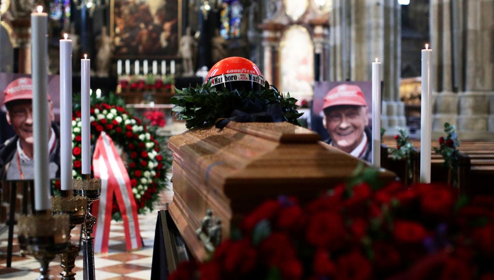 Un retrato del piloto austriaco Niki Lauda colocado junto a su ataúd y su casco en la capilla ardiente