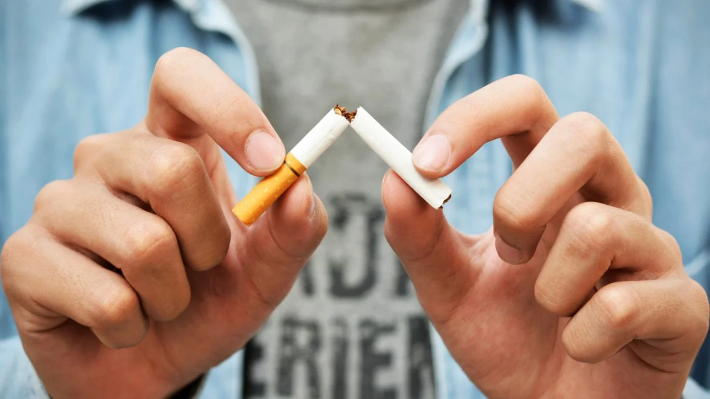 Imagen de archivo de un joven rompiendo un cigarro. Imagen de archivo de un joven rompiendo un cigarro.