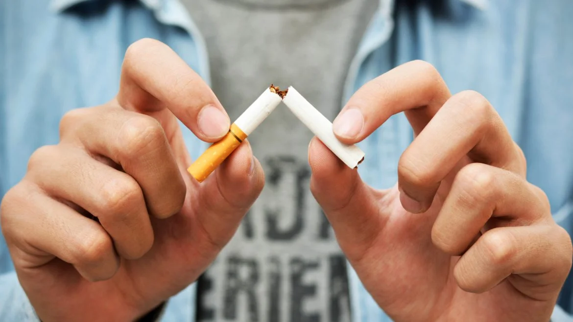 Imagen de archivo de un joven rompiendo un cigarro.