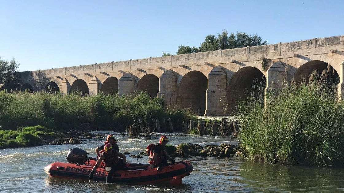 Bomberos trabajando en el rescate de un hombre ahogado en el río Jarama,