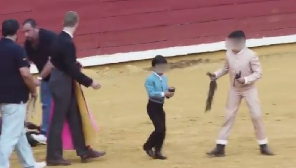 Varios niños participan en una corrida de toros de Córdoba: lucen las orejas que acaban de cortar al animal vivo