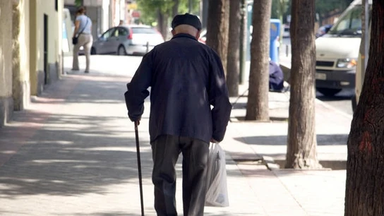 Un jubilado camina en una calle.  Un jubilado camina en una calle.