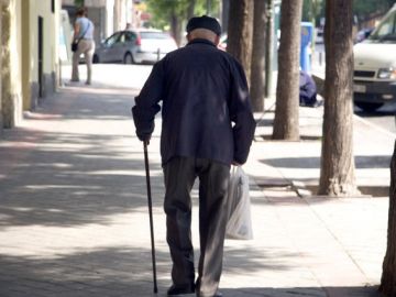 Un jubilado camina en una calle. Un jubilado camina en una calle.