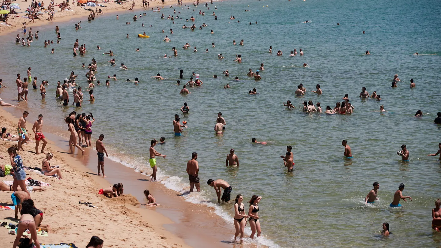 Unos bañistas se refrescan en la playa de la Nova Icaria de Barcelona Unos bañistas se refrescan en la playa de la Nova Icaria de Barcelona
