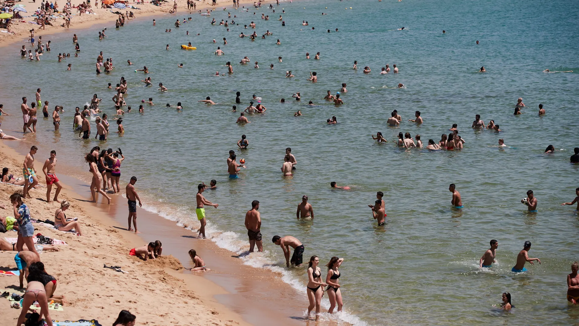 Unos bañistas se refrescan en la playa de la Nova Icaria de Barcelona