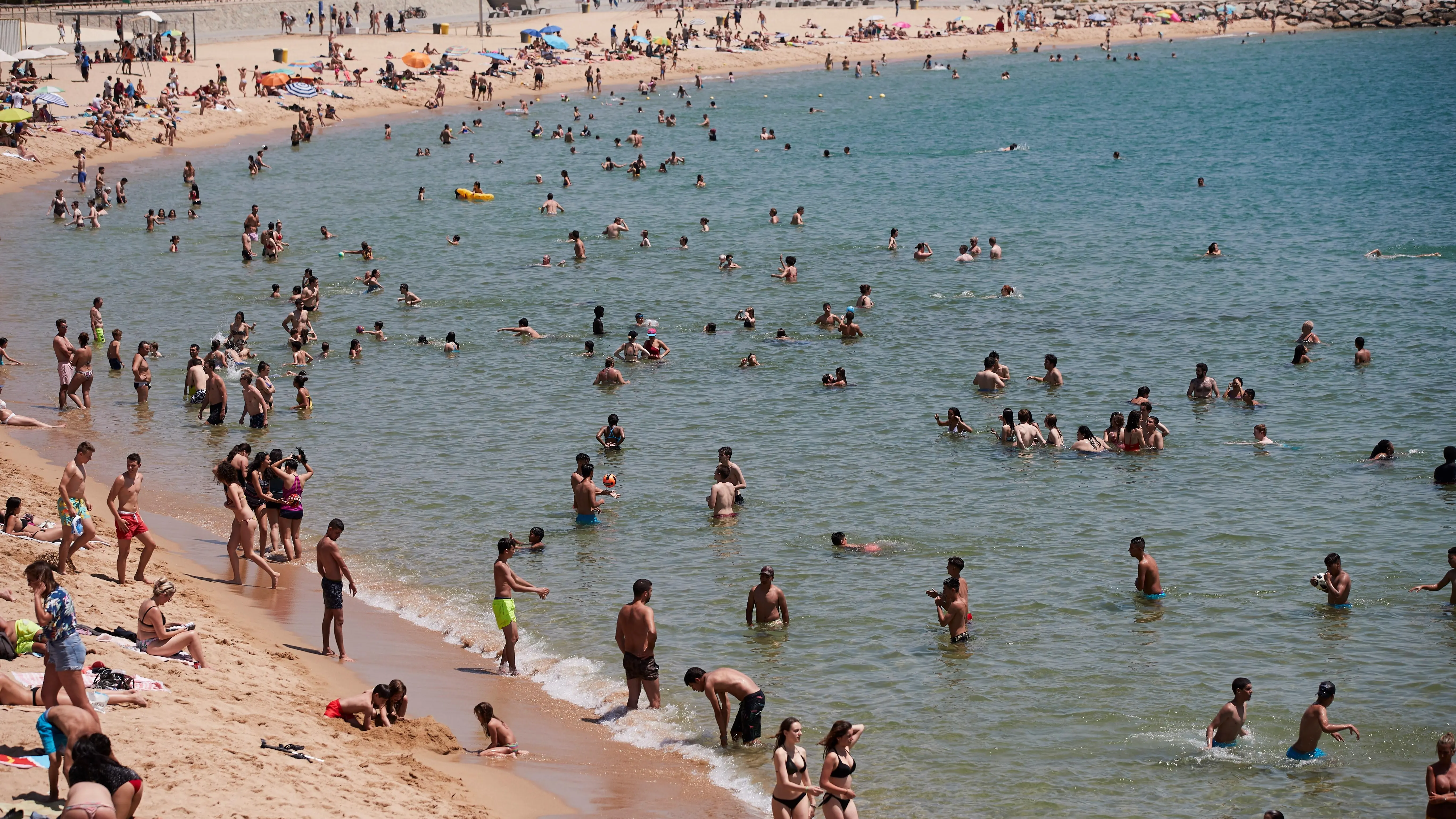 Unos bañistas se refrescan en la playa de la Nova Icaria de Barcelona