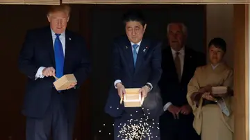 Donald Trump alimentando a carpas junto a Shinzo Abe