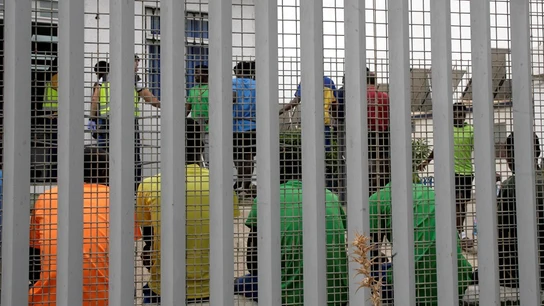 Un grupo de migrantes subsaharianos tras el muro del Centro de Estancia Temporal de Inmigrantes Un grupo de migrantes subsaharianos tras el muro del Centro de Estancia Temporal de Inmigrantes.