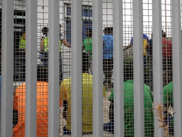 Un grupo de migrantes subsaharianos tras el muro del Centro de Estancia Temporal de Inmigrantes Un grupo de migrantes subsaharianos tras el muro del Centro de Estancia Temporal de Inmigrantes