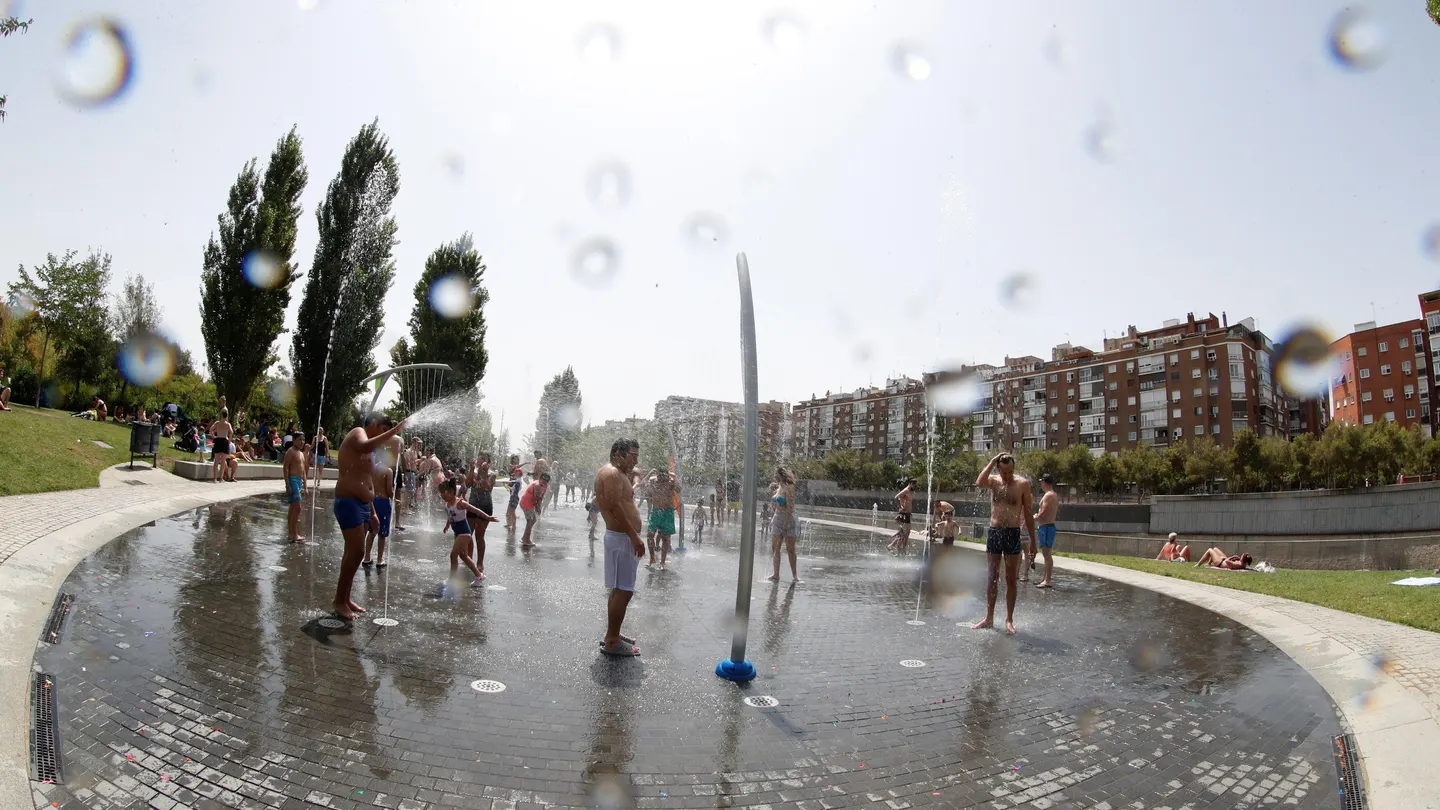Grupos de personas se refrescan en la fuentes verticales de Madrid Río Grupos de personas se refrescan en la fuentes verticales de Madrid Río