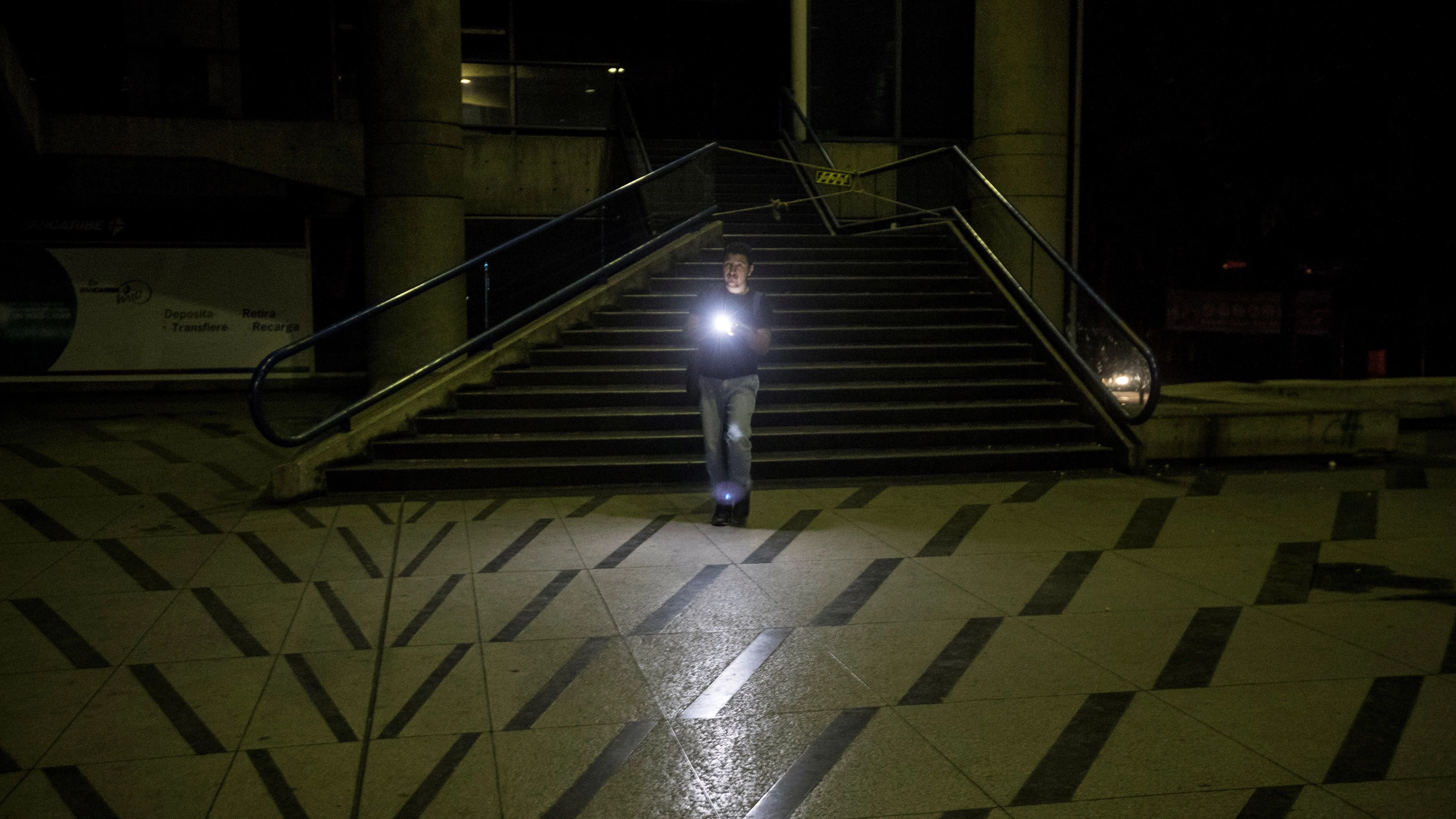 Un hombre camina en la calle durante el apagón en Caracas 