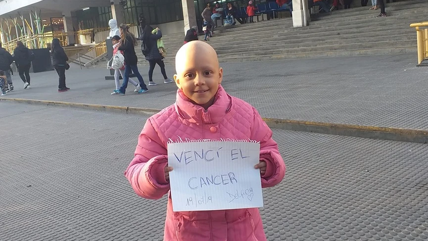 Delfina anunció con este cartel y posando frente al hospital que había logrado curarse.