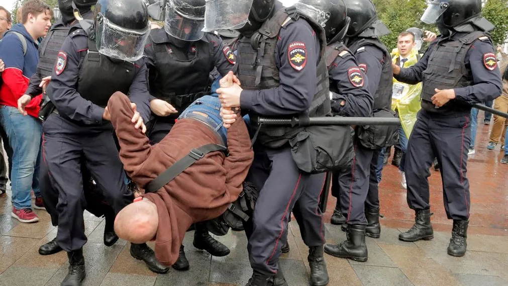 Varios policías antidisturbios se llevan en volandas a un manifestante