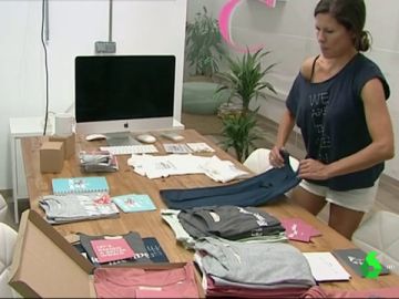 Mujer doblando ropa en una empresa de moda sostenible Mujer doblando ropa en una empresa de moda sostenible