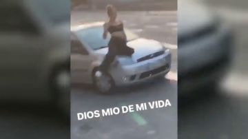 Un conductor temerario transporta a una mujer en el capó de su coche