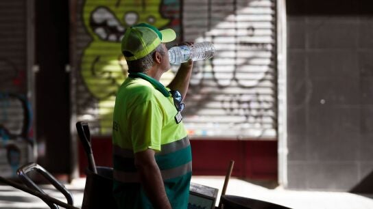 Un trabajador del servicio de limpieza bebe agua en Madrid