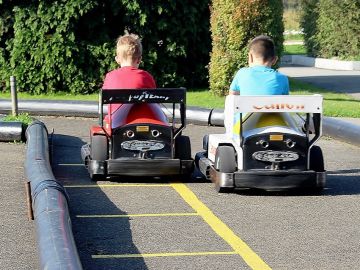 Dos niños conduciendo karts Dos niños conduciendo karts