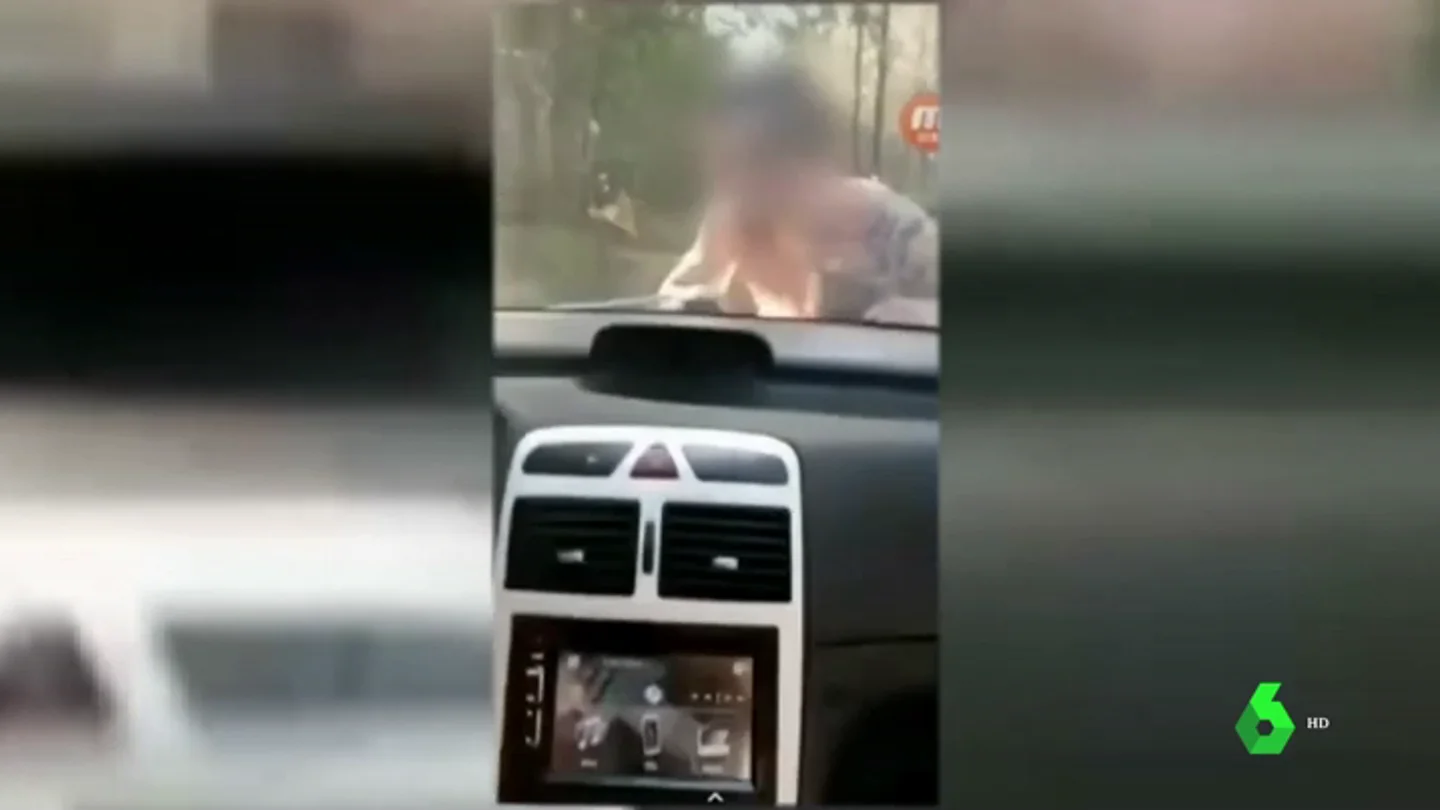 Se graba conduciendo con una persona sobre el capó de su coche Se graba conduciendo con una persona sobre el capó de su coche