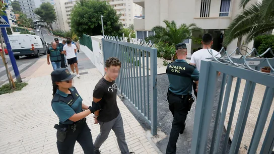 Los cinco investigados entran custodiados al apartamento donde presuntamente tuvo lugar la agresión sexual Los cinco investigados entran custodiados al apartamento donde presuntamente tuvo lugar la agresión sexual