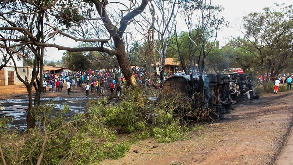 Personas congregadas alrededor del camión cisterna incendiado.