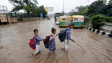 Varios niños van a la escuela tras las inundaciones en Nueva Delhi