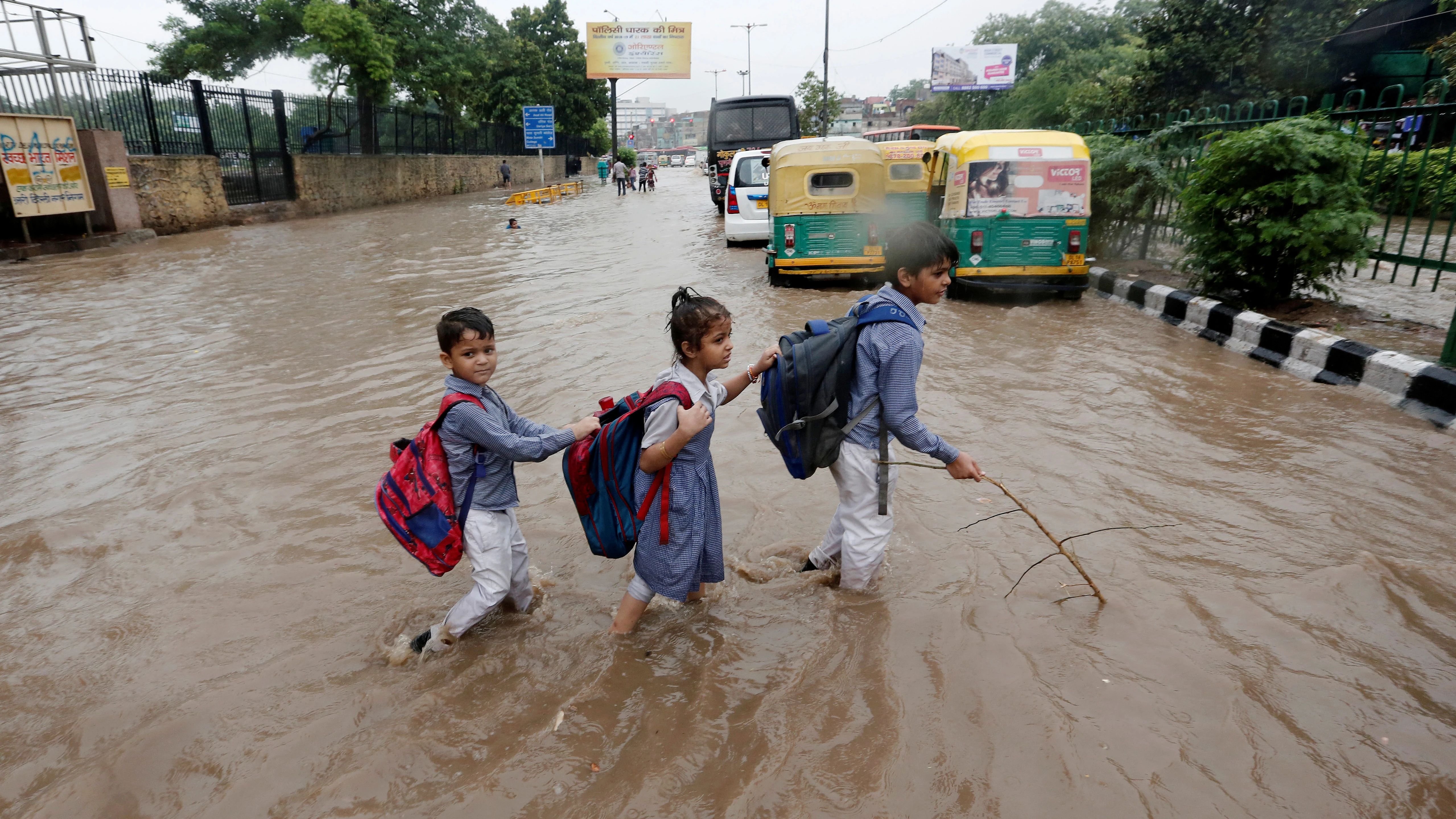 Varios niños van a la escuela tras las inundaciones en Nueva Delhi