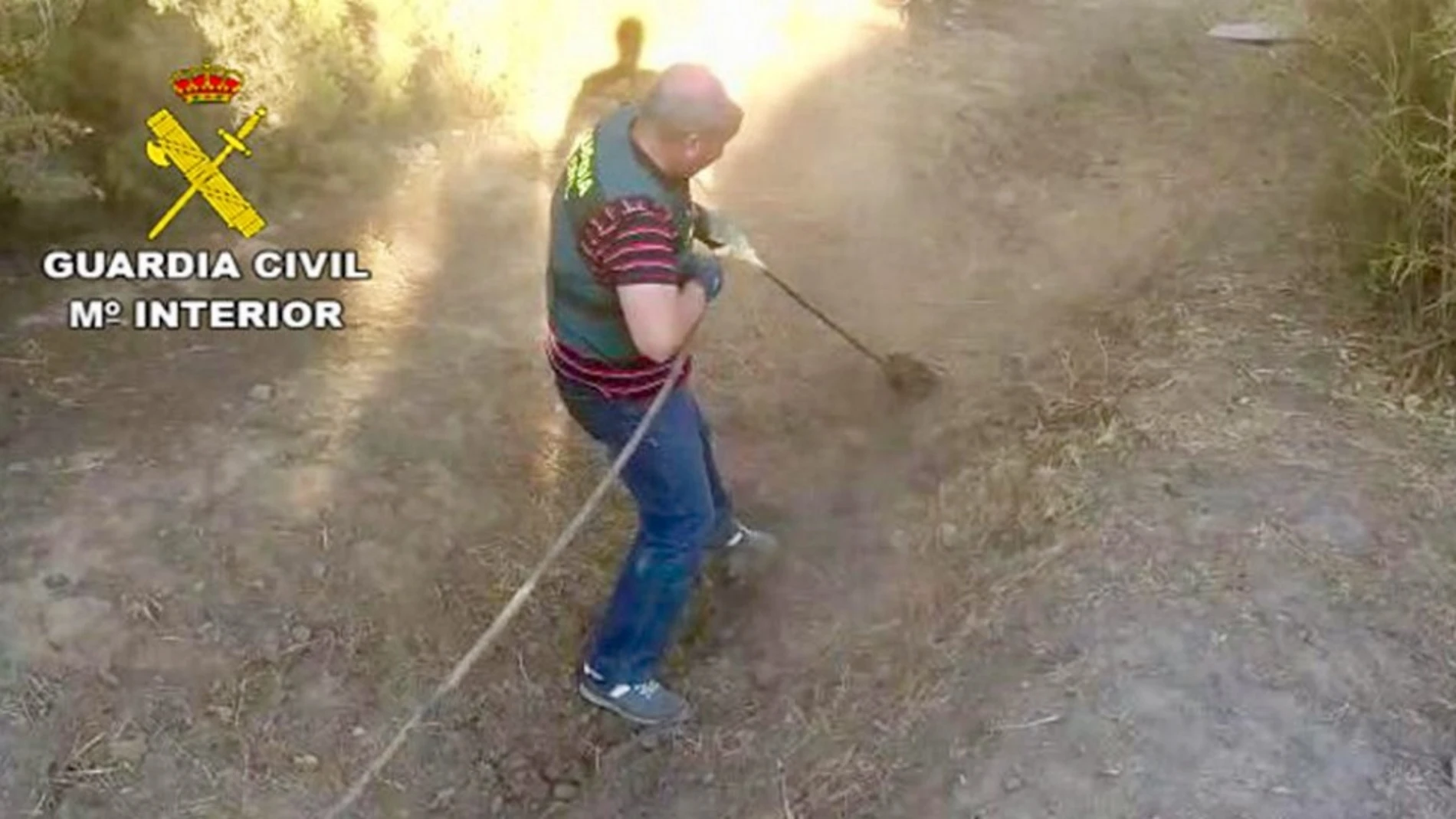 Agente de la Guardia Civil desenterrando la manguera enganchada al oleoducto