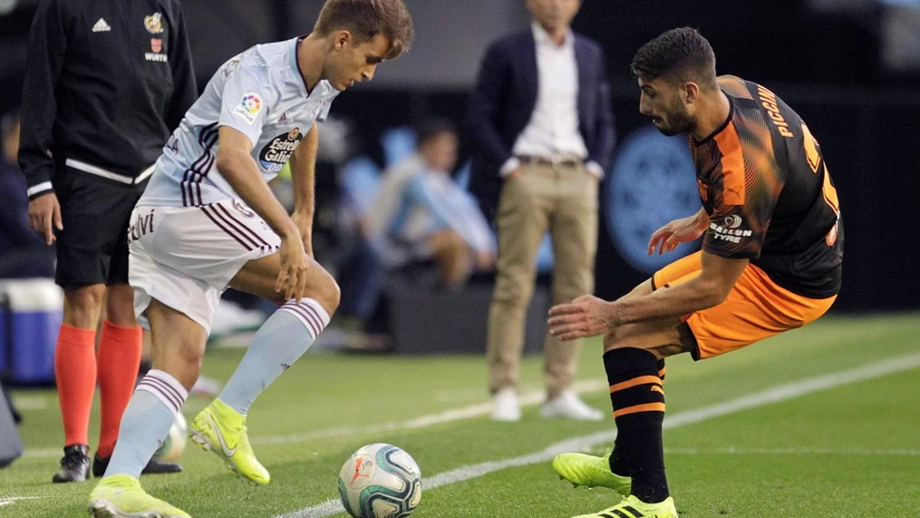 El centrocampista del Celta Denis Suárez (i) pelea un balón con el defensa italiano del Valencia Cristiano Piccini 