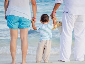 Padres y su hijo a la orilla de la playa Padres y su hijo a la orilla de la playa