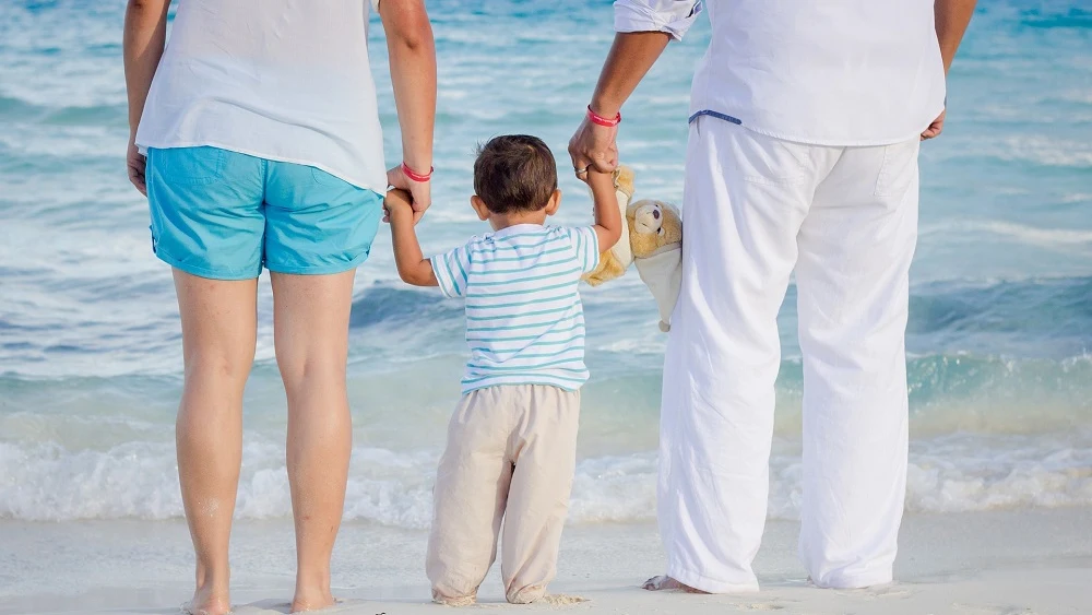 Padres y su hijo a la orilla de la playa .