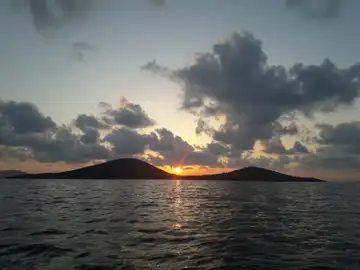 Puesta de sol entre montes en Cartagena Bella instantánea del mar y el horizonte