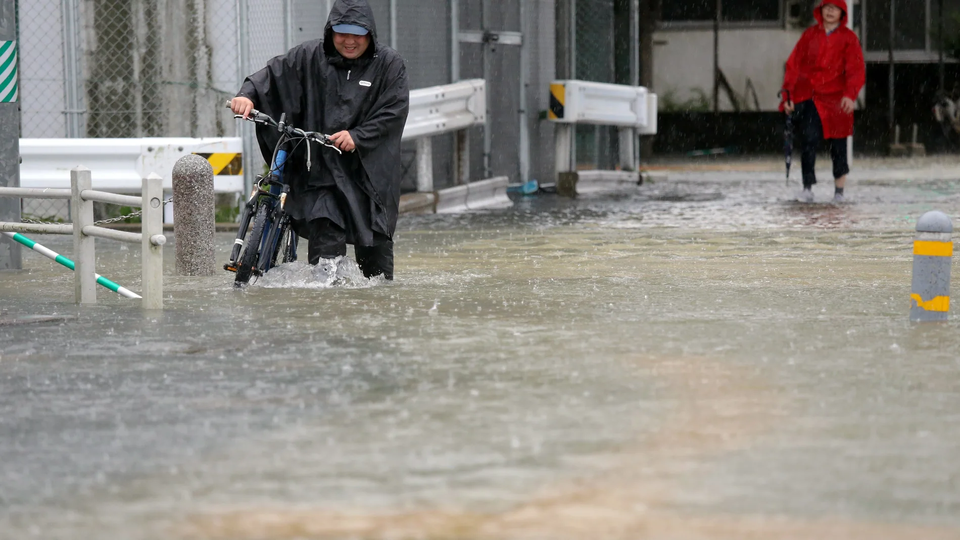 Imagen de un hombre circulando por una calle inundada.