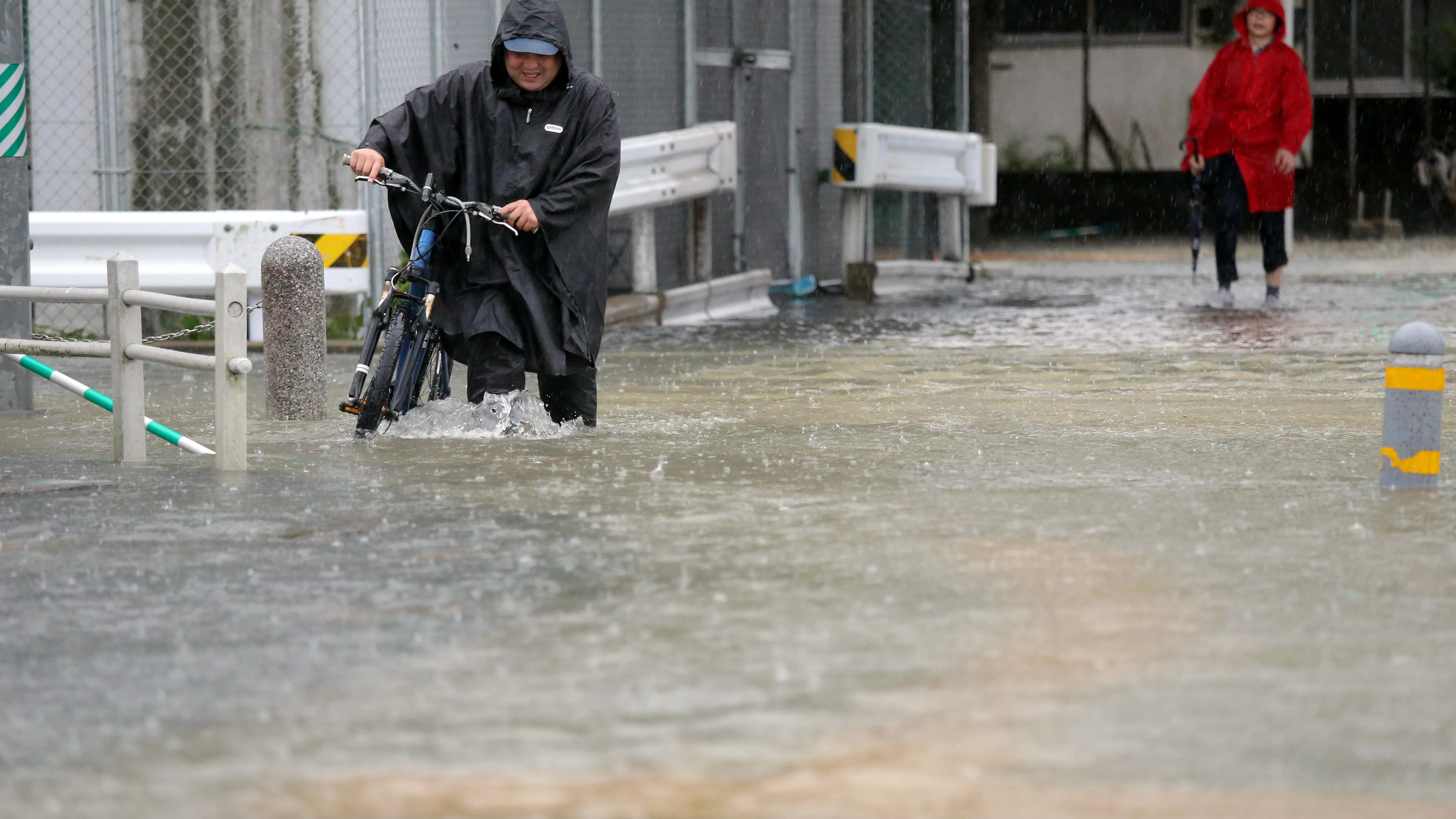 Imagen de un hombre circulando por una calle inundada.