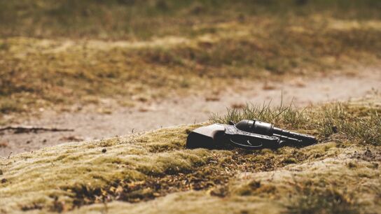 Rev&oacute;lver tirado en el suelo.