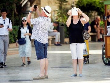 Varios turistas toman fotografías con sus teléfonos Varios turistas toman fotografías con sus teléfonos