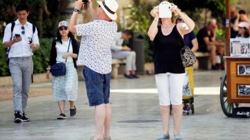 Varios turistas toman fotografías con sus teléfonos