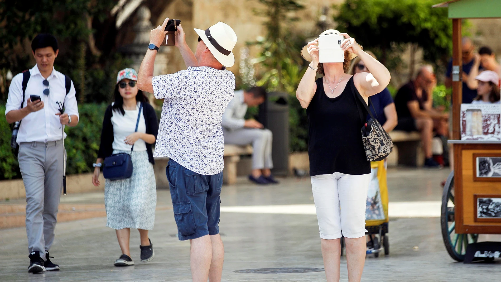 Varios turistas toman fotografías con sus teléfonos