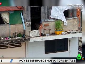 Un niño juega en la cornisa de un edificio de más de 10 metros de altura Un niño juega en la cornisa de un edificio de más de 10 metros de altura