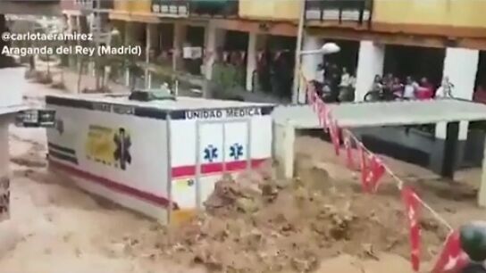 Una ambulancia es arrastrada por el agua durante las inundaciones en la localidad madrile&ntilde;a de Arganda del Rey