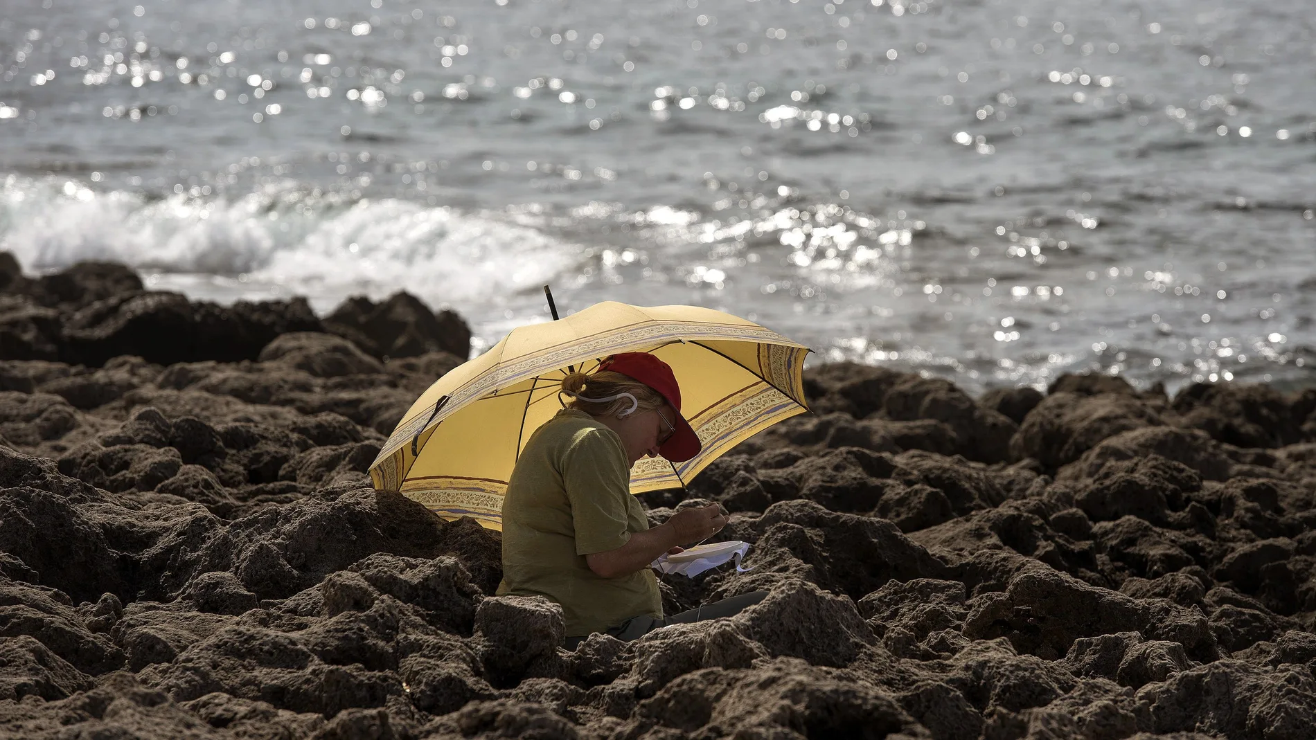 Una persona descansa junto al mar en el municipio de Sant Lluís, Menorca