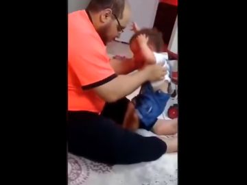 El padre detenido, durante la agresión a su bebé