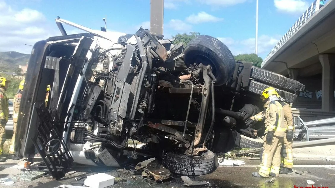 El camión ha quedado destrozado por la caída desde el puente.