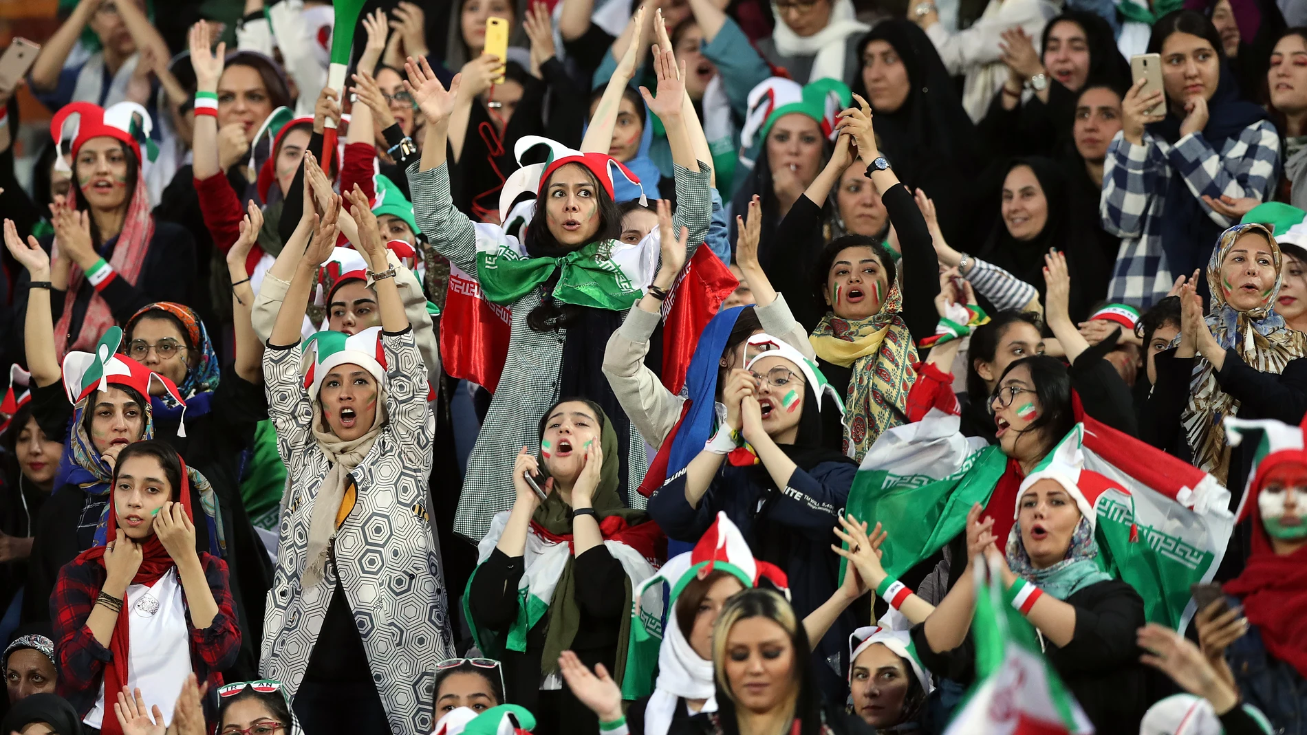 Mujeres festejan la victoria de Irán ante Camboya desde dentro del estadio Azadi, en Teherán.