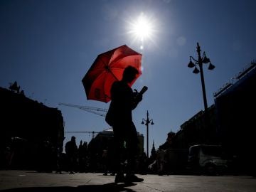 Un joven se protege del sol con un paraguas (Archivo) Un joven se protege del sol con un paraguas (Archivo)