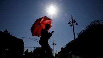 Un joven se protege del sol con un paraguas (Archivo)