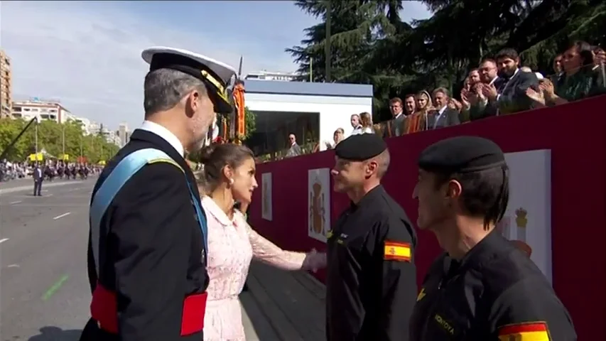 Los reyes saludan al paracaidista que ha chocado contra una farola en el desfile del 12O