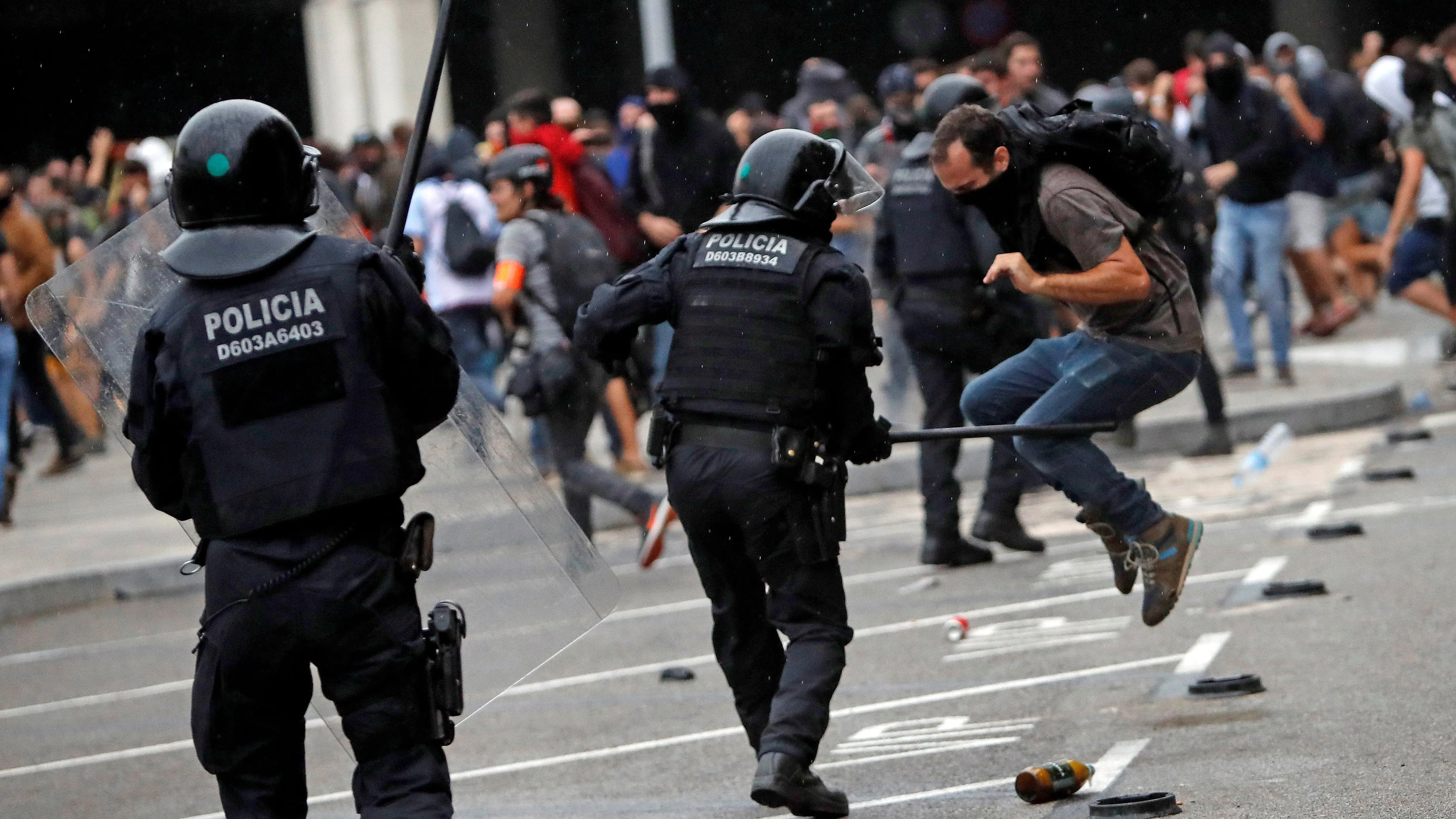 Miembros de los Mossos d'Esquadra cargan contra los centenares de personas que se agolpan ante el Aeropuerto del Prat