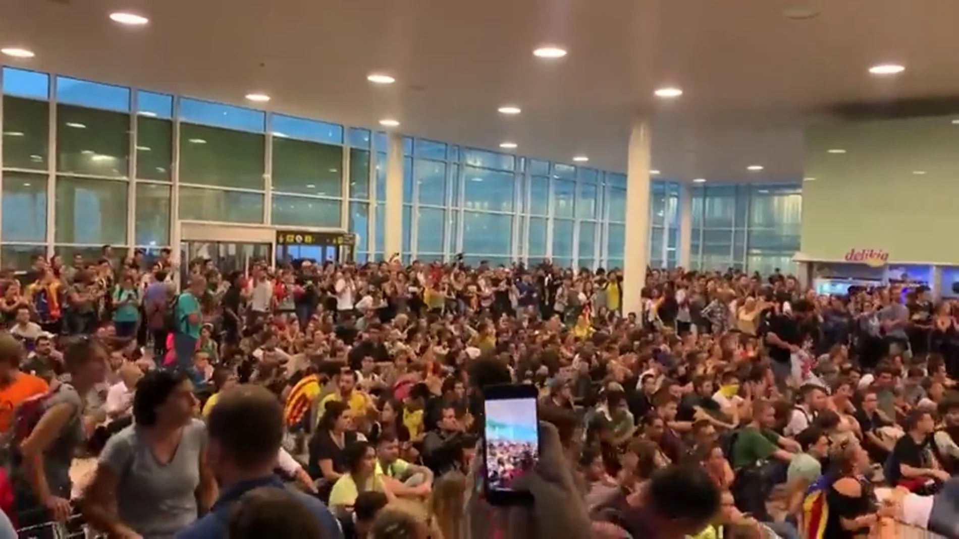 Los manifestantes entonan el 'Bella Ciao' en una sentada dentro del aeropuerto de Barcelona